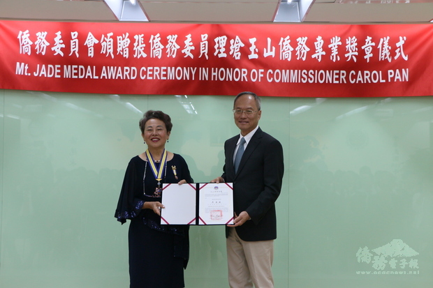 吳新興(右)親自頒發玉山僑務專業獎章予張理瑲(左)。