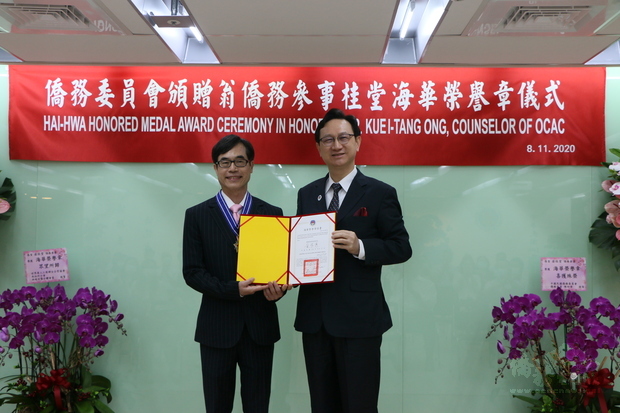 委員長童振源(右)頒發海華榮譽章證書予翁桂堂(左)。