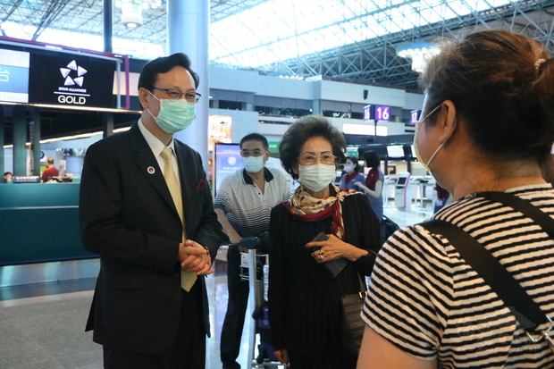 僑委會委員長童振源(左)前往機場關心搭乘返泰專機的僑胞。