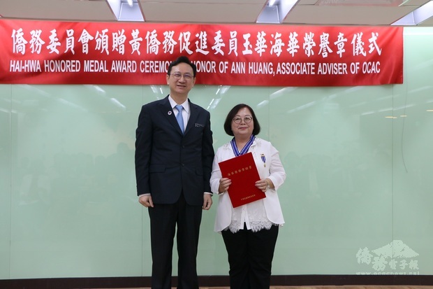 僑委會委員長童振源(左)頒贈海華榮譽章予黃玉華。