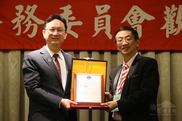 委員長童振源(左)頒發銀質獎牌給吳怡明，感謝吳怡明慷慨解囊，響應「一千萬個口罩 一千萬個愛心」活動。