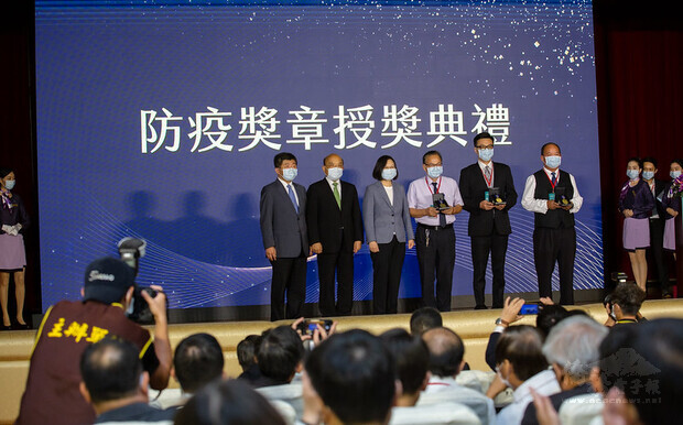 總統逐一頒發防疫獎章予各得獎者並合影。