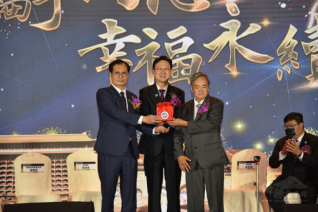 在僑委會委員長童振源（中）監交下，世界臺灣商會26屆總會長施至隆（左）將印信交接給27屆總會長梁輝騰（右）。