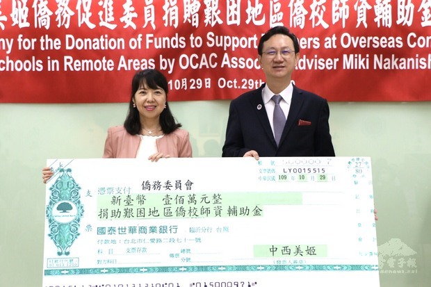 中西美姬(左)捐贈新臺幣100萬元挹注僑委會艱困地區僑校師資輔助金，委員長童振源(右)代表受贈。