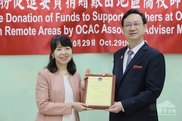 童振源(右)頒贈獎牌感謝中西美姬(左)長期的善行。