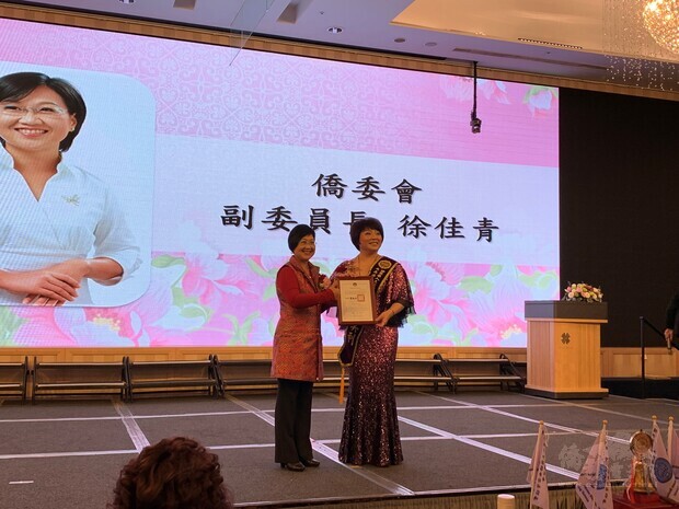 僑委會副委員長徐佳青(左)頒贈賀狀予大高雄分會滿任會長沈美利(右)