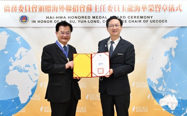 委員長童振源(右)頒發海華榮譽章予蘇玉龍(左)