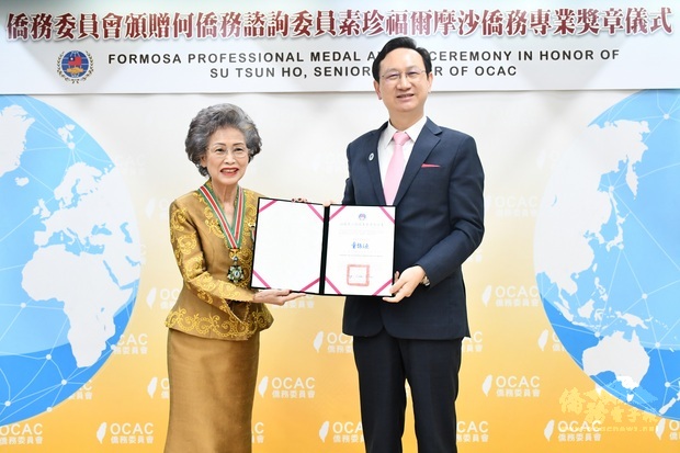 委員長童振源(右)頒發福爾摩沙僑務專業獎章予何素珍(左)。