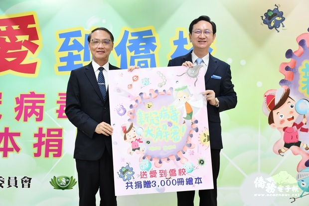顏博文(左)代表慈濟基金會捐贈「新冠病毒大解密」繪本,由童振源(右)代表接受。