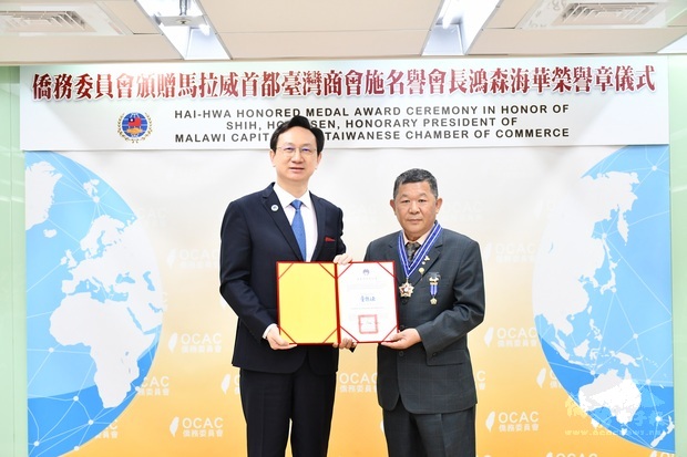 委員長童振源(左)頒發海華榮譽章予施鴻森(右)