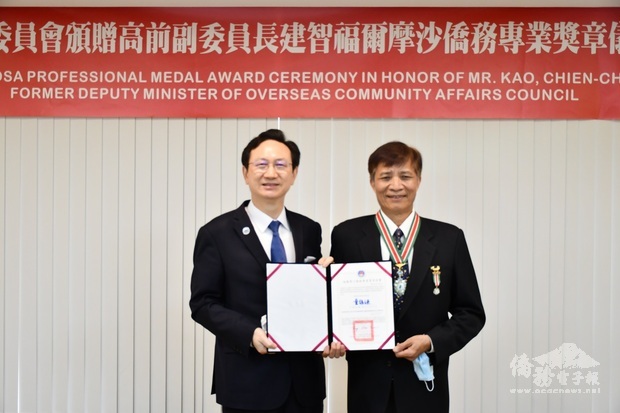 童振源(左)頒贈福爾摩沙僑務專業獎章予高建智。