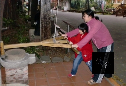 親子合力推動石磨，回味古早生活。