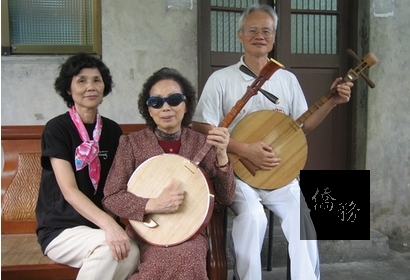 楊秀卿（中）與薪傳弟子鄭美（左）、葉文生（右）於住家門口合影。