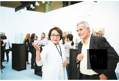 楊惠姍藉由佛像創作表達對生命體悟,也同時反映歐美社會不安。圖為楊惠姍(左)與英國玻璃雙年展主席安德魯布華頓合影。(琉璃工房提供)