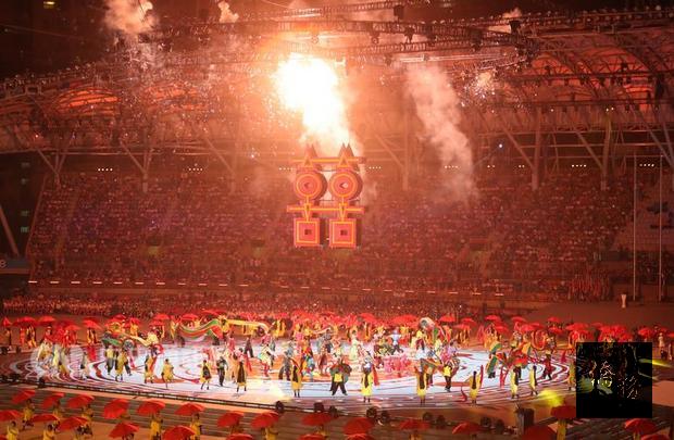 台北世大運19日晚間在台北田徑場舉行開幕式,安排多段文化節目演出,讓現場觀眾目不暇給。圖為大型紅色雙喜字樣搭配煙火,絢爛奪目。(中央社提供)