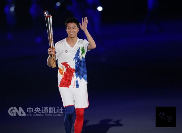 台北世大運19日晚間在台北田徑場舉行開幕式,聖火傳遞儀式展開,第一棒火炬手江宏傑(圖)高舉火炬跑入場內。 (中央社提供)