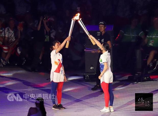 在台北田徑場約2萬名觀眾、各國運動員面前,台北世大運聖火點燃儀式展開,台灣頂尖運動員桌球江宏傑、羽球戴資穎(右)、射箭譚雅婷(左)擔任火炬手,接力繞場傳遞聖火。 (中央社提供)