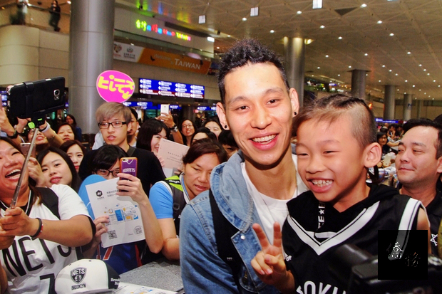 美國職籃(NBA)布魯克林籃網隊台裔球星林書豪(右3)返台,看見小球迷精心打扮成自己的模樣來接機,林書豪開心地抱起小球迷合影。