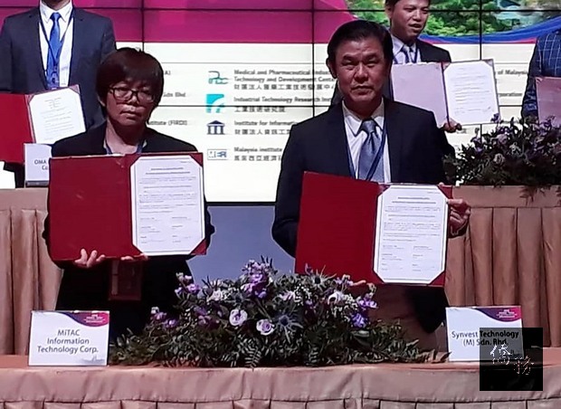 台灣神通資訊科技專案經理王繹銨與（左）馬來西亞欣邁科技董事劉偉明（右）19日於台馬產業論壇簽署合作備忘錄，以引進「智慧圖書館」系統科技予馬來西亞。（中央社提供）