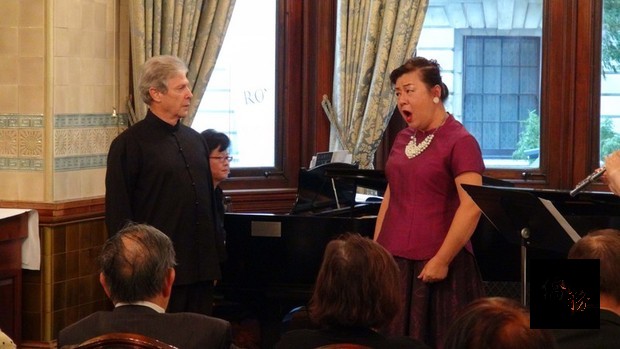 女高音盧瓊蓉與男中音席維斯崔19日在倫敦全國自由俱樂部對唱「天黑黑」，表情生動。（中央社提供）