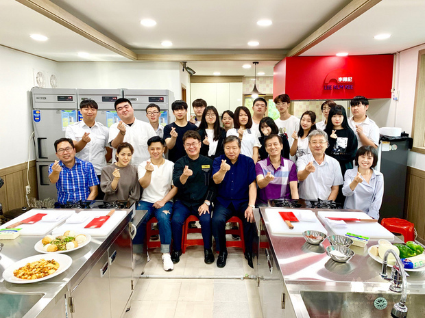 被韓國媒體讚譽為中華名廚的呂敬來(前左4)19日在漢城僑中向烹飪社團學生傳授廚藝後,與漢城僑中理事長譚紹榮(前左5)、漢城僑中校長于植盛(前右2)及學生們合影。(中央社提供)