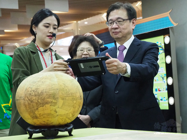 國立故宮博物院與台北醫學大學攜手合作，推出「故宮X北醫藝起玩」數位微型系列特展，台北醫學大學校長林建煌（右）運用AR技術近距離觀察青銅器等故宮國寶的結構與紋理。（北醫大提供）