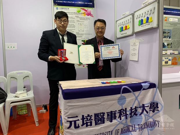 元培醫事科技大學醫檢系副教授徐治平（右）、學生陳瓏（左），帶著團隊設計的「一種核酸模型之雙螺旋結構」參加2020泰國IPITEX國際發明展，獲銀牌獎肯定。（中央社提供）
