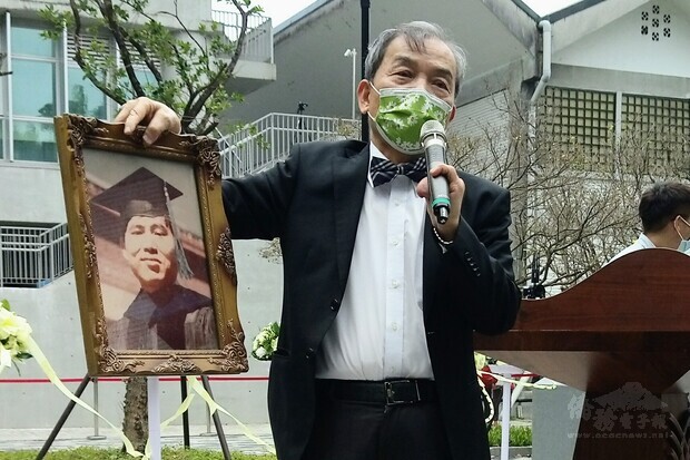 陳文成二姊夫戴憲明拿起陳文成的遺照,感嘆年輕早逝。