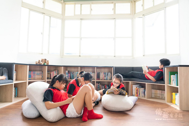 無有設計創意總監張智舜幫東華大學附設實驗小學改造教室空間，透過挪動教師座位「解放」圖書角，在搭配木質家具和軟墊，營造舒適的閱讀空間。（張智舜提供）