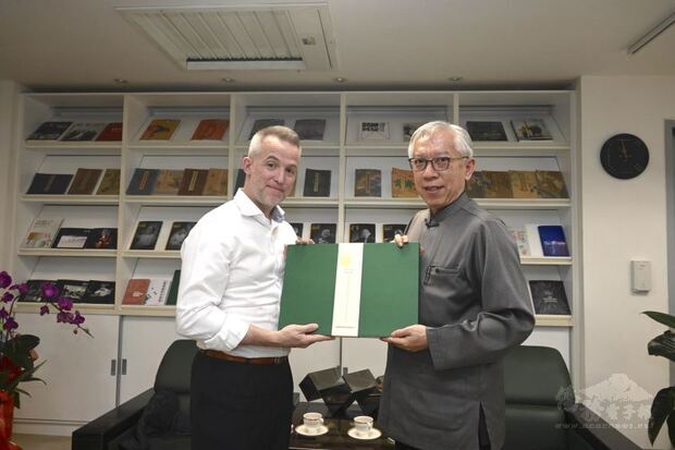 加拿大駐臺辦事處呂明銳處長對國美館展覽深感興趣，國美館梁永斐館長(右)特致贈展覽專輯