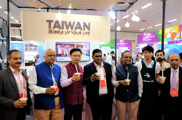 貿協董事長黃志芳（左3）16日在新德里舉辦的台灣形象展中，帶領印度貴賓到珍珠奶茶館體驗台灣珍珠奶茶。（中央社提供）