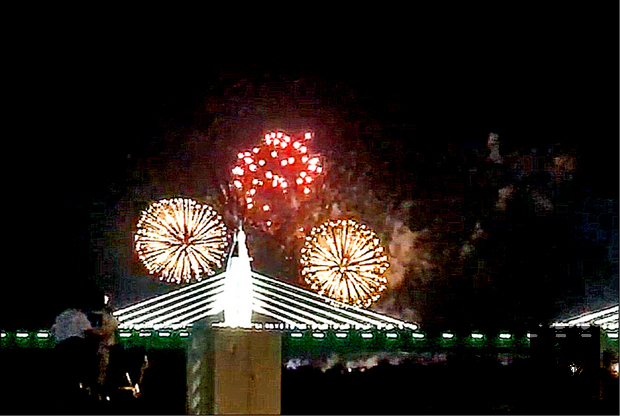 王功漁火節開幕，現場施放高空煙火與鄰近台61線上的脊背橋相互輝映，引起民眾大呼好美。（自由時報提供）