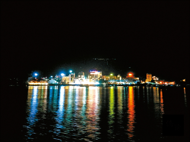 日月潭首發夜航，遊艇經過伊達邵碼頭，岸際燈光映照潭面，美不勝收。（自由時報提供）