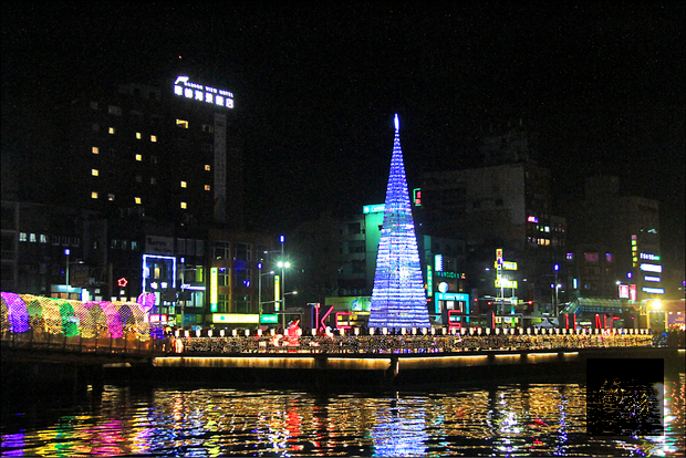 基隆昨晚在海洋廣場點亮高十七米、由七千個寶特瓶打造成的環保耶誕樹。（自由時報提供）