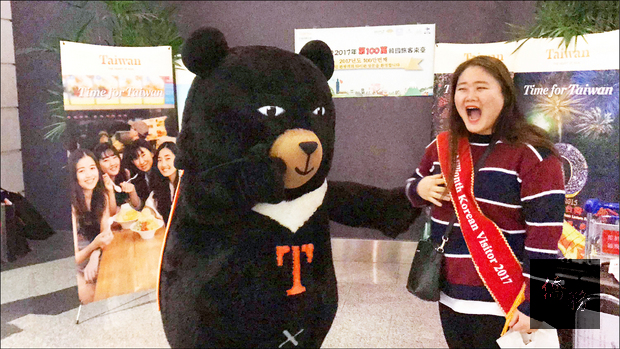 韓國旅客來台人次前晚首度突破百萬大關，首位第百萬名韓客金惠仁（右）和女性友人第一次造訪台灣，觀光局派出喔熊（左）接機。（自由時報提供）