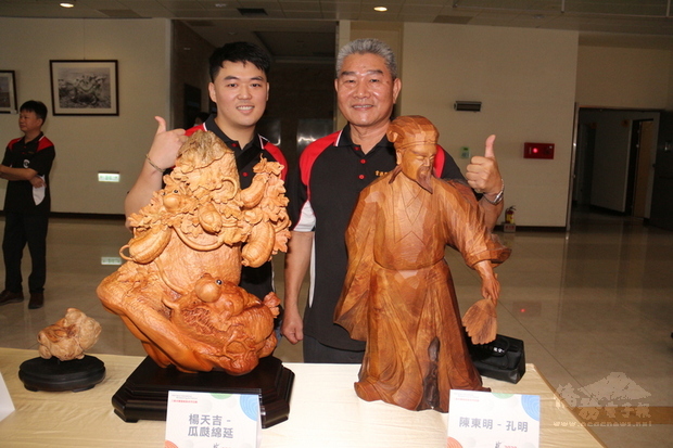 苗栗縣「2020三義木雕藝術節」將於中秋節連假登場，苗栗縣政府文化觀光局22日舉辦宣傳記者會，安排木雕大師陳東明（右）、楊天吉（左）師徒聯手創作，場內也展示兩人各自擅長的木雕藝術作品。（中央社提供）