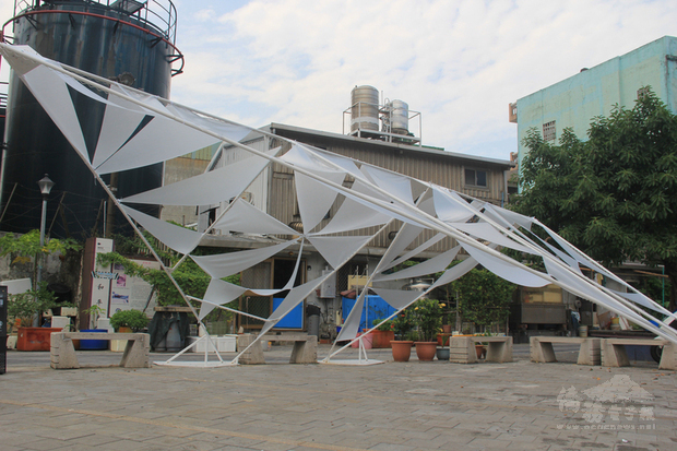 跨越基隆和平橋抵達社寮福德宮,藝術裝置「幸福水路方舟」以白色鐵架勾勒出船隻,搭配霧面三角型布幔,與湛藍天空遙相映襯,呼應和平島作為台灣迎向世界入口。