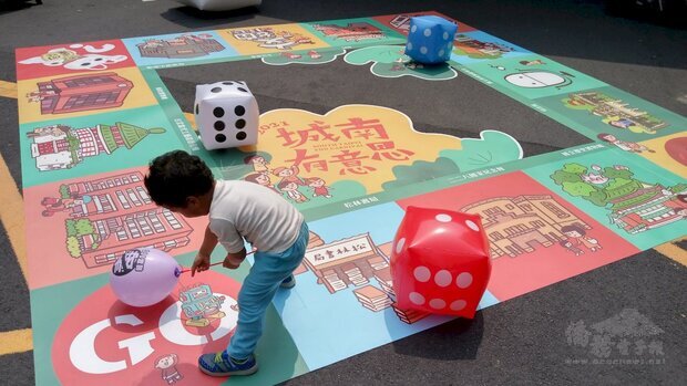 小朋友在牯嶺街上的「春日晒書市集」大玩骰子樂。(陳國維 攝)
