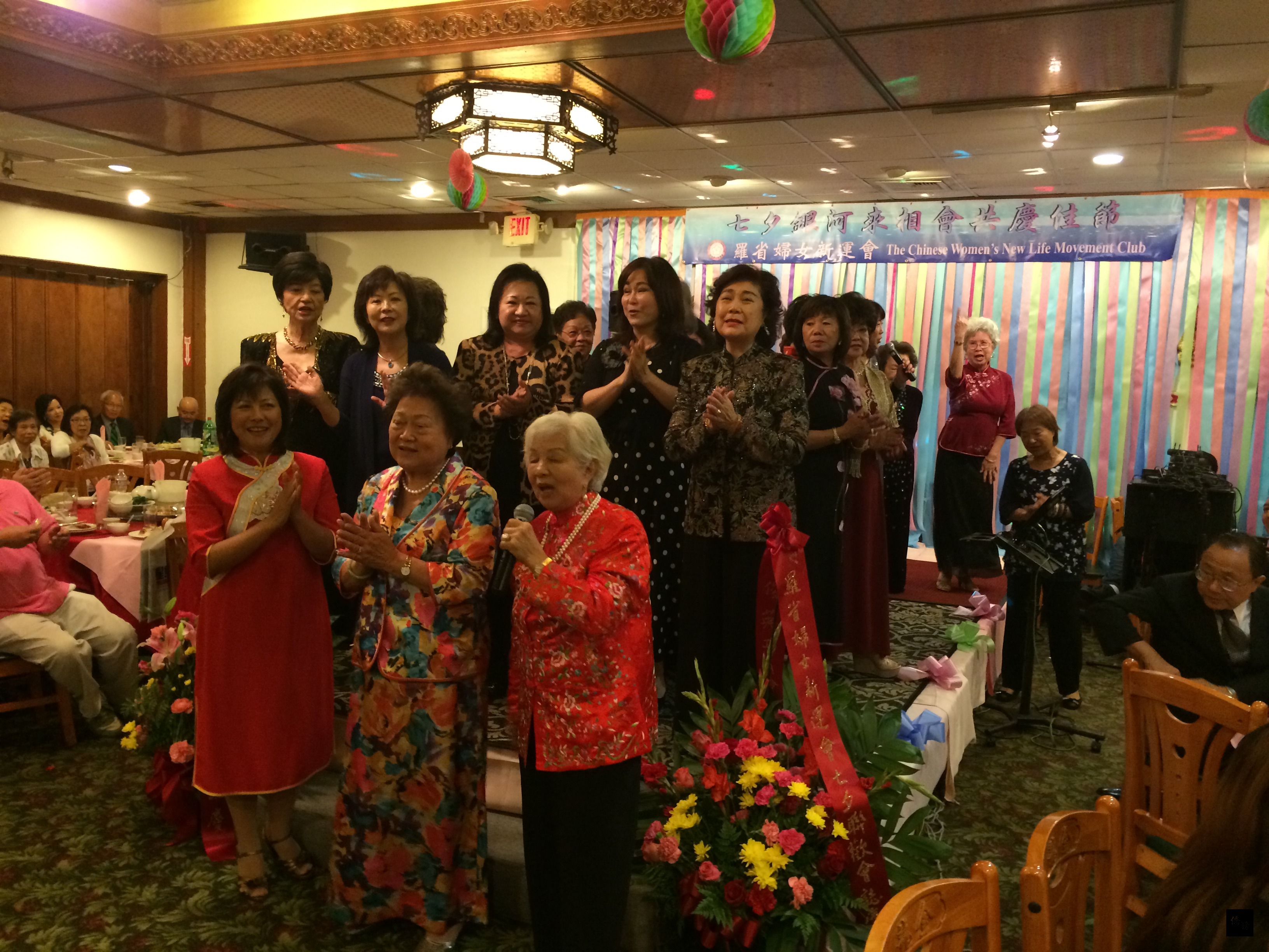 羅省婦女新運會20日舉辦「七夕銀河來相會共慶佳節」活動,主席方美瓊(前排左)、顧問黃鐘艷真(前排中)、顧問吳李秀群(前排右)、副主席豔桃紅(後排右一)、副主席朱碧雲(後排左二)及會員幹部一起上台獻唱。(洛杉磯僑教中心提供)