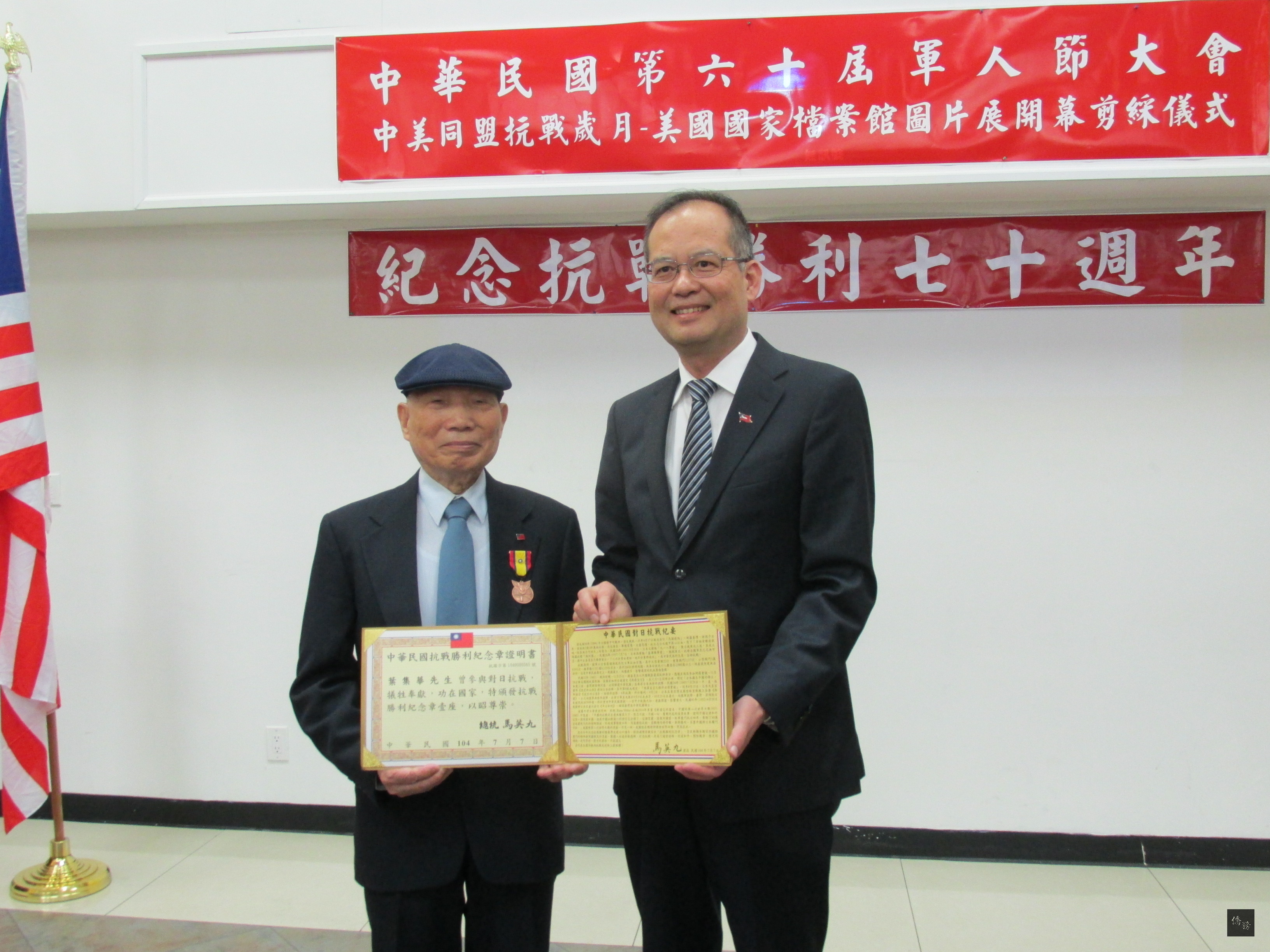 中華民國退伍軍人協會及中國國民黨美東支部及多個團體共同主辦「中美同盟抗戰歲月—美國國家檔案館圖片展」，駐紐約辦事處處長章文樑頒發抗戰勝利紀念章給抗戰老兵葉集華。（紐約僑教中心提供）