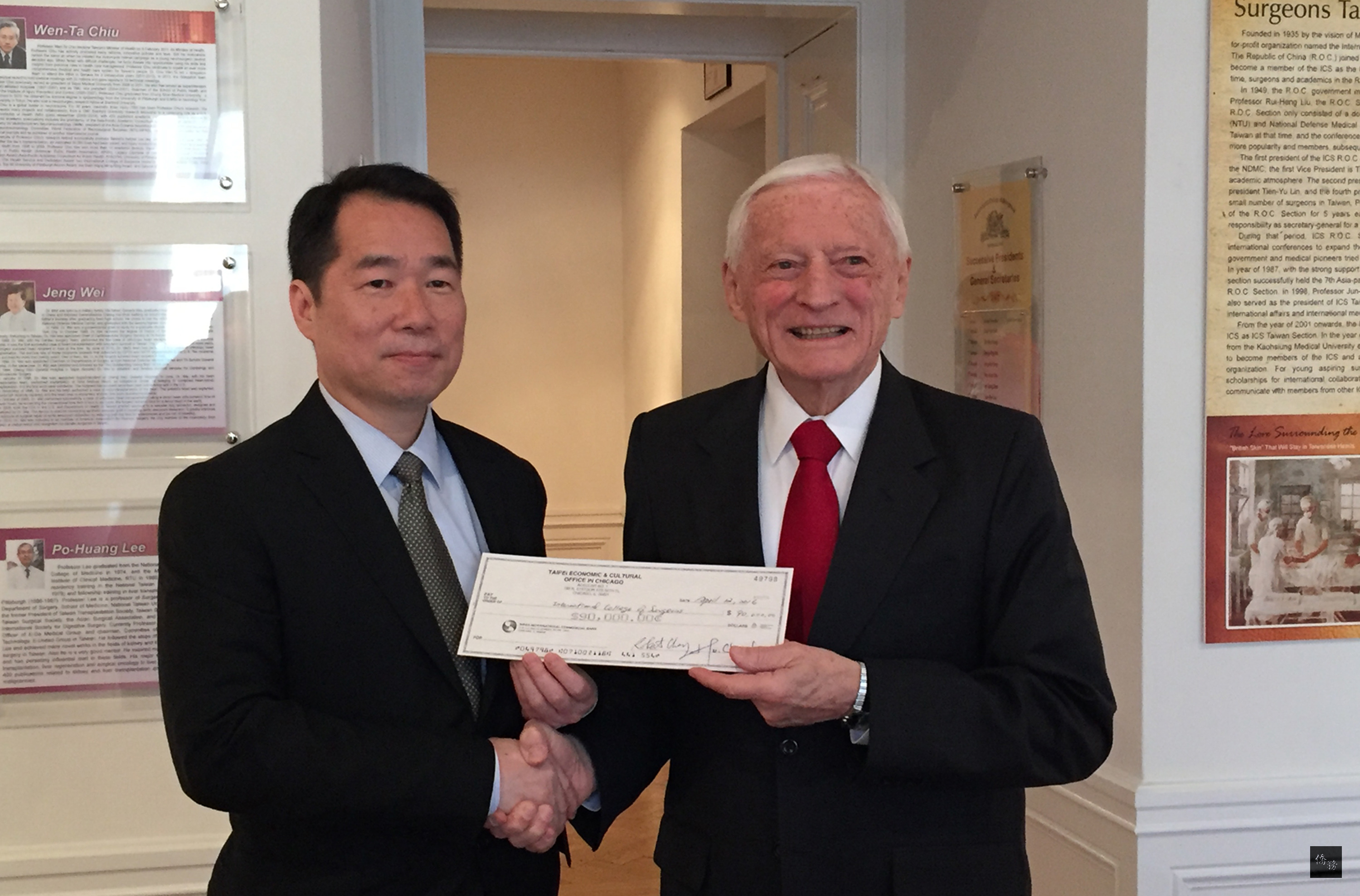 駐芝加哥辦事處處長何震寰(左)13日(當地時間)代表政府,將援助國際外科學會(ICS)人道醫療計畫第1期補助款9萬美元支票,交給ICS執行長唐罕。(中央社提供)