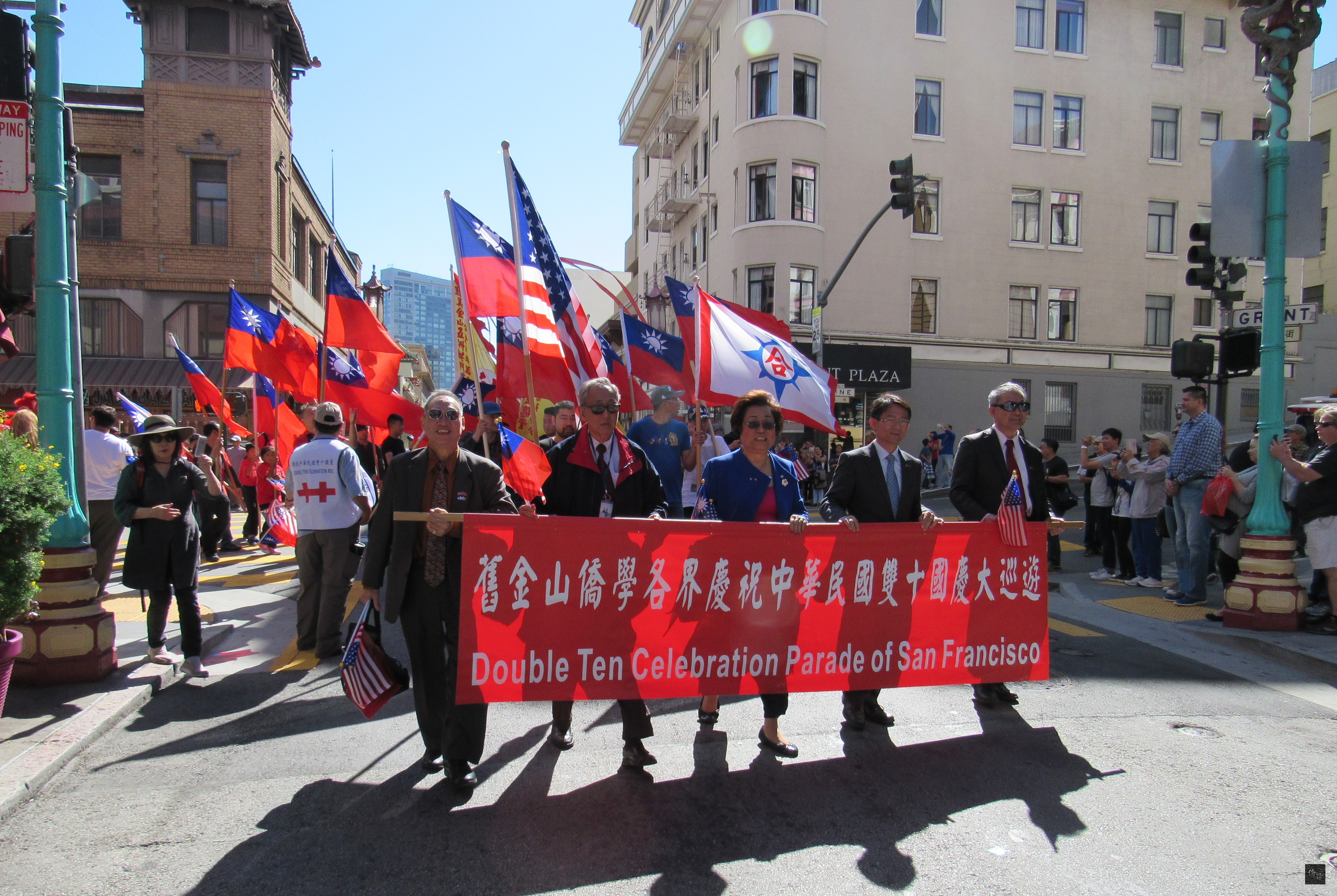 慶祝中華民國105年雙十國慶巡遊在舊金山華埠聖瑪麗廣場熱鬧展開，駐舊金山辦事處副處長李盈興（左二）及金山僑教中心主任吳迪文（左一）所組成的隊伍領隊前行。（金山僑教中心提供）