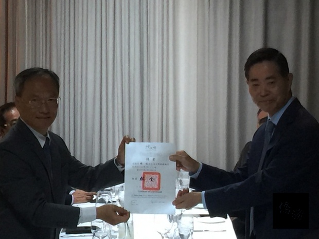 吳新興(左)頒發行政院政務顧問聘書給楊信(右)。（洛杉磯華僑文教中心提供）