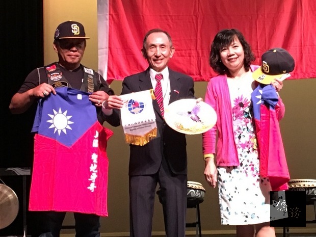 聖地牙哥僑務委員汪慎叔（中）代表喬學界贈送九天民俗技藝團長許振榮（左）和文化訪問團團長王映陽（右）紀念國旗T恤和大聯盟聖地牙哥教士隊棒球帽。（世界日報提供）