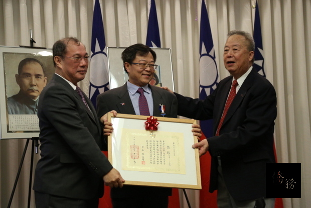 會長李昌緒(右)、駐美代表處領務組長吳文齡(左)將「榮光襟綬榮譽章」頒給傑出義工閆文鼎。（世界日報提供）