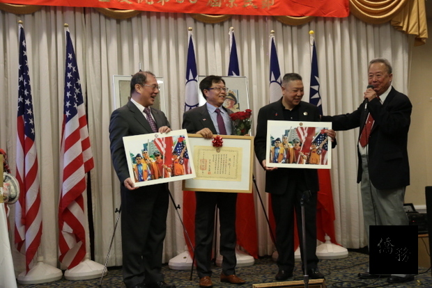 會長李昌緒(右一)、駐美代表處領務組長吳文齡(左一)將「榮光襟綬榮譽章」頒給傑出義工閆文鼎(左二)。（世界日報提供）