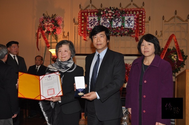 馬鍾麟(中)向譚瑪麗(左)轉致唁電及海華獎章。