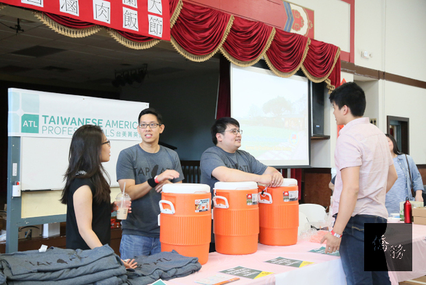 台美菁英協會亞特蘭大分會共同會長詹靖剛(左二)和邵康(左三)在滷肉飯節上，兼賣茶飲料和會服，作為該會的活動經費。