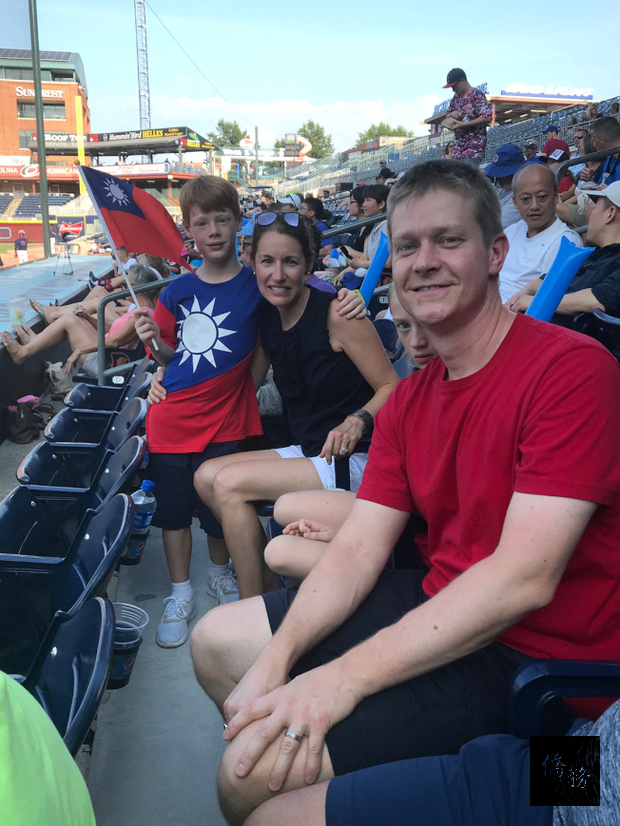 在台灣出生的8歲奇根(左),穿著中華民國國旗T恤,揮舞中華民國國旗,和家人一起為中華隊加油。