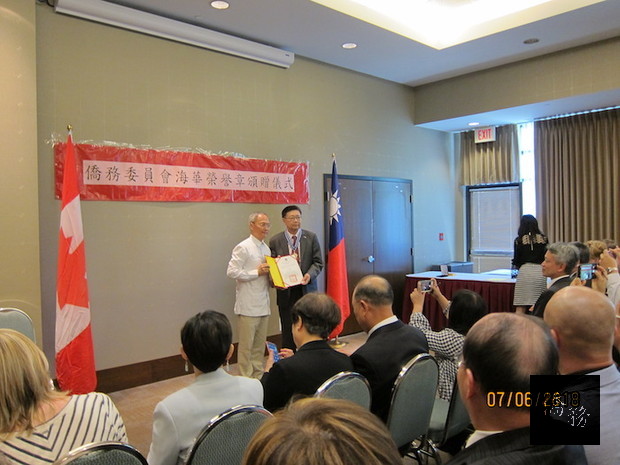 吳新興(左)頒贈海華榮譽章予僑務諮詢委員許平宗(右)